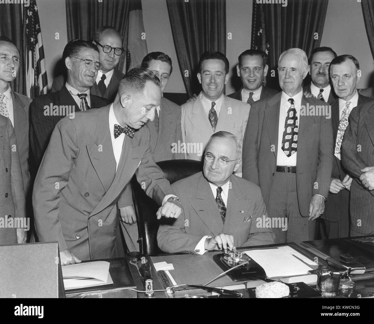 President Harry Truman about to push a button activating a new generator at Grand Coulee Dam. May 20, 1949. Members of Congress from a number of Western states look on. - (BSLOC 2014 15 76) Stock Photo