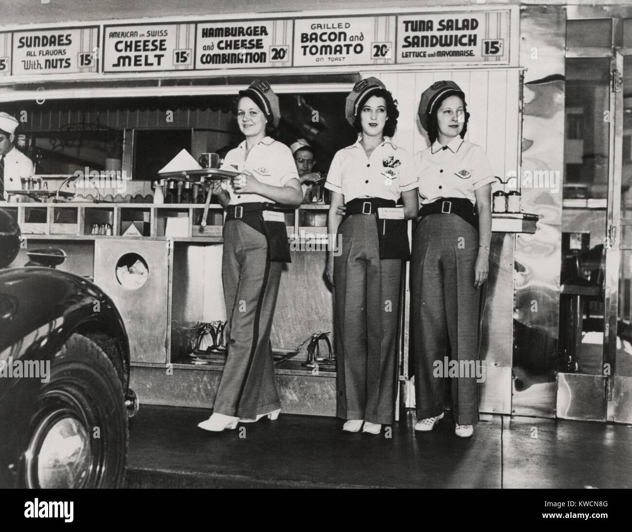Drive-in restaurant in Hollywood, Los Angeles. June 29, 1938. The waitresses wear pseudo Highway Patrol Uniforms. The Fast Food menu includes: Hamburger and Cheese Combination; American and Swiss Cheese Melts, Grilled Bacon and Tomato on Toast; and Tuna Salad Sandwich. - (BSLOC 2014 17 115) Stock Photo