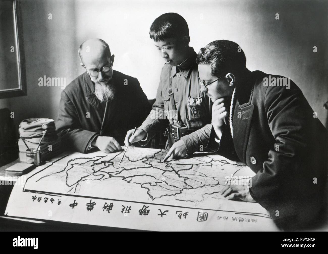 Chinese army officer and two missionaries plot the advance of Communist forces. Christian missions in the provinces of Hunan, Sichuan, Anhui, Jiangxi, Fujian, and Yunnan had fallen under Communist occupation. Nov. 1935. - (BSLOC 2014 15 155) Stock Photo
