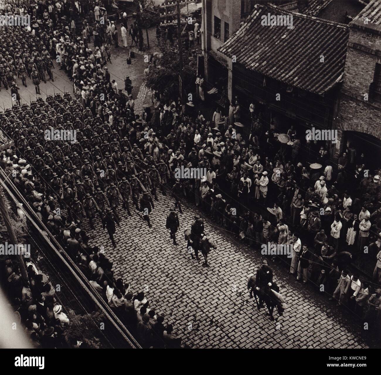 Overhead view of provincial troops marching along a city street in China. Photo taken in Kiangsu Province or Yunnan Province. By Arthur Rothstein, 1946. - (BSLOC_2014_15_166) Stock Photo