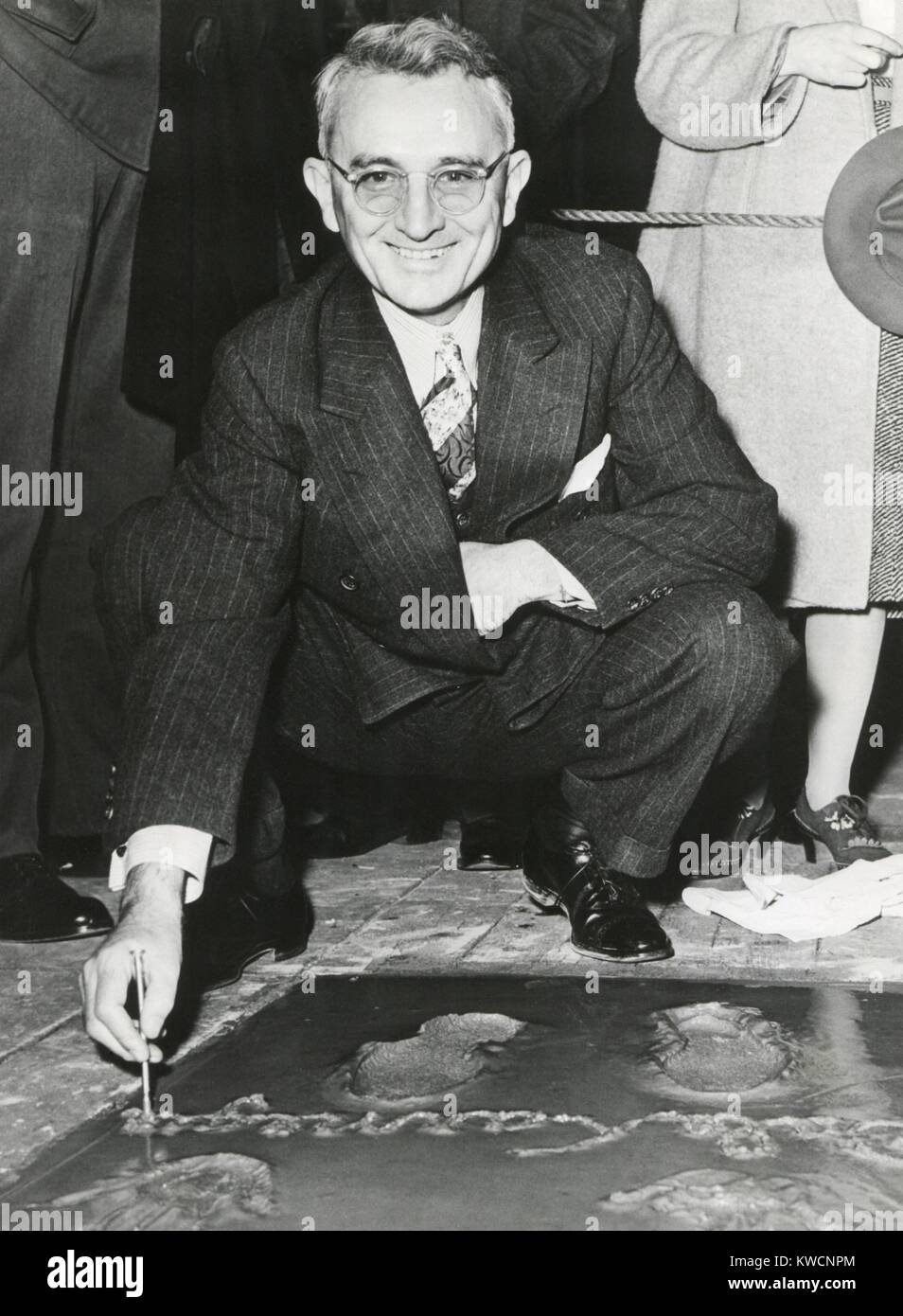 Dale Carnegie, signing his concrete slab at Grauman's Chinese Theatre. His book, 'How To Win Friends and Influence People' of 1931 is a classic and still relevant self-help book. Ca. 1930s. - (BSLOC 2014 17 201) Stock Photo