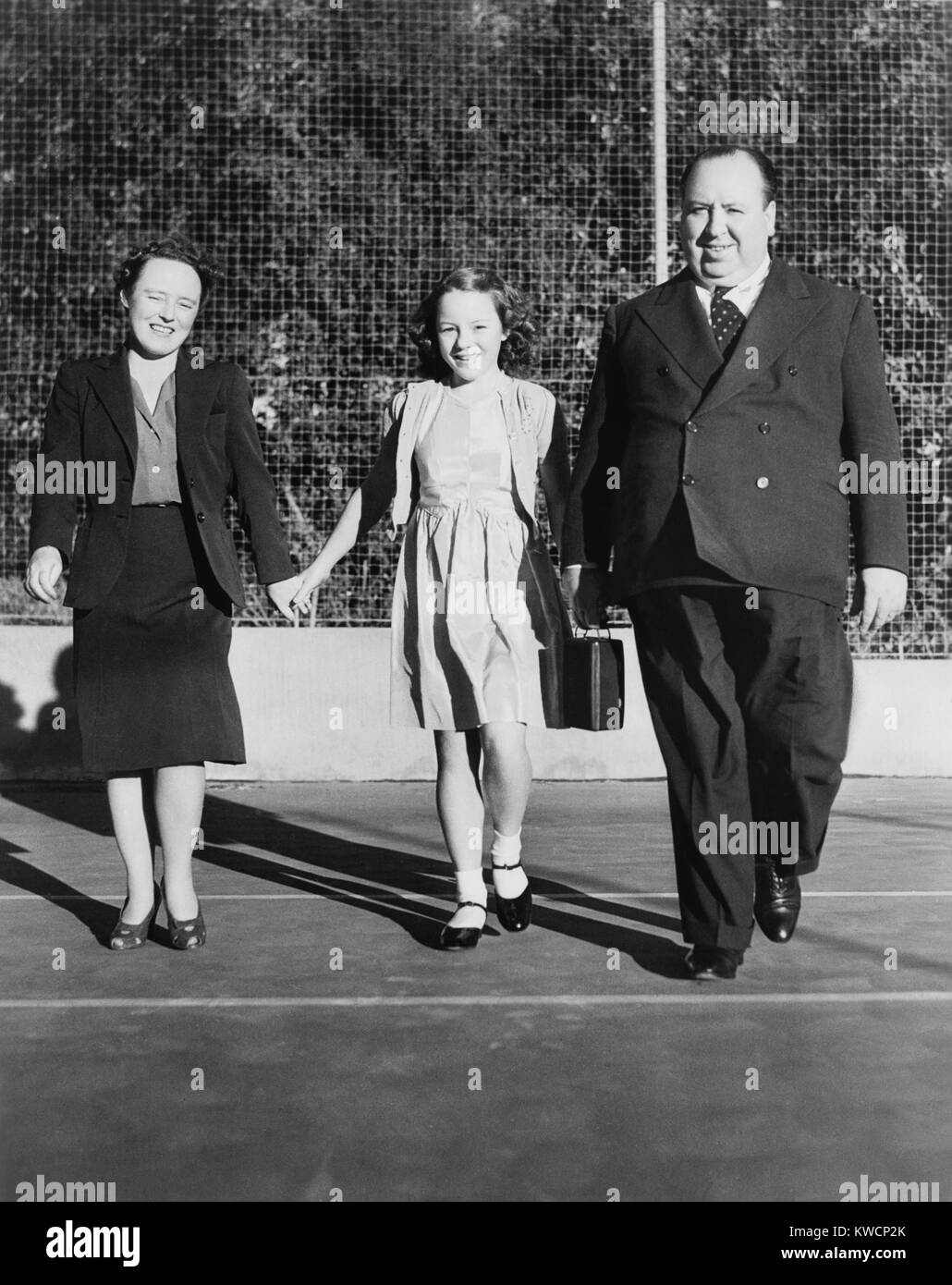 Alfred Hitchcock strolling about the grounds of his Bel Air estate. He is with his wife, Alma Reville, and his daughter, Patricia. Ca. 1942 - (BSLOC 2014 17 79) Stock Photo