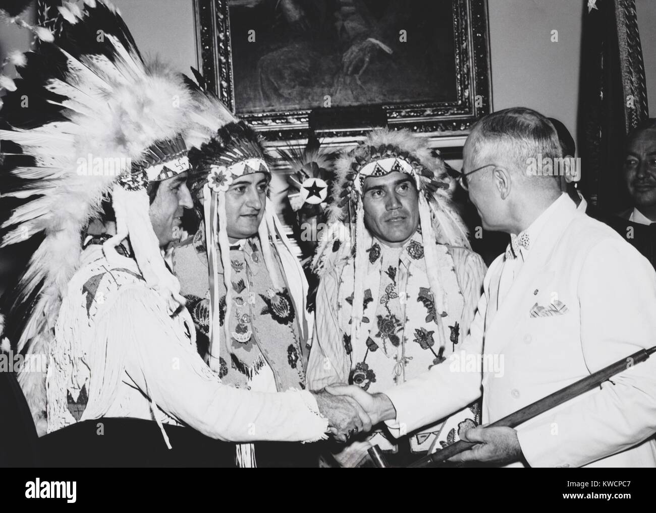 President Truman was presented a pipe said to have once been smoked by Sitting Bull. He had just signed the Indian Claims Commission Act. Aug. 13, 1946. The purpose of the Act was to settle every claim Indian tribes could possibly have against the U.S. within five years of it's passage. L-R: Ish-Ti-Opi, (Choctaw), Caddo, OK; Reginald Curpy, (Uncompahgre Ute), Ft. Duchesne, UT; Julius Murray (Uintah Ute), Ft. Duchesne, UT; President Truman. - (BSLOC 2014 15 74) Stock Photo