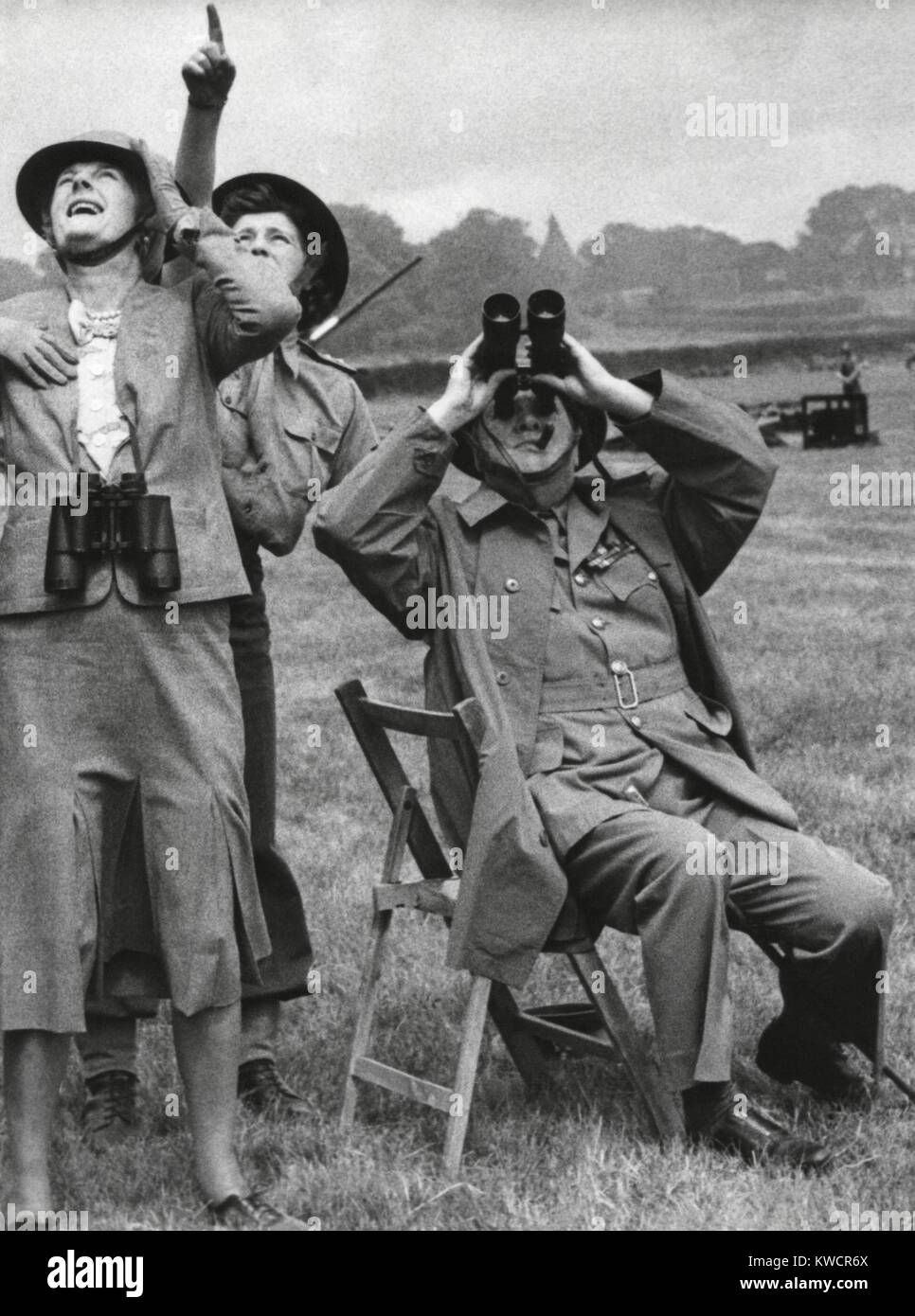 Prime Minister and Mrs. Churchill watching a fighter intercept a German 'buzz bomb' overhead. With them is their daughter, Subaltern Mary Churchill, an officer at the mixed battery in Southern England to defend against the 'Flying Bomb'. Churchill is wearing the Uniform of Honorary Colonel of the 5th Cinque Ports, Battalion Royal Sussex Regiment. July 1, 1944. - (BSLOC 2014 17 37) Stock Photo