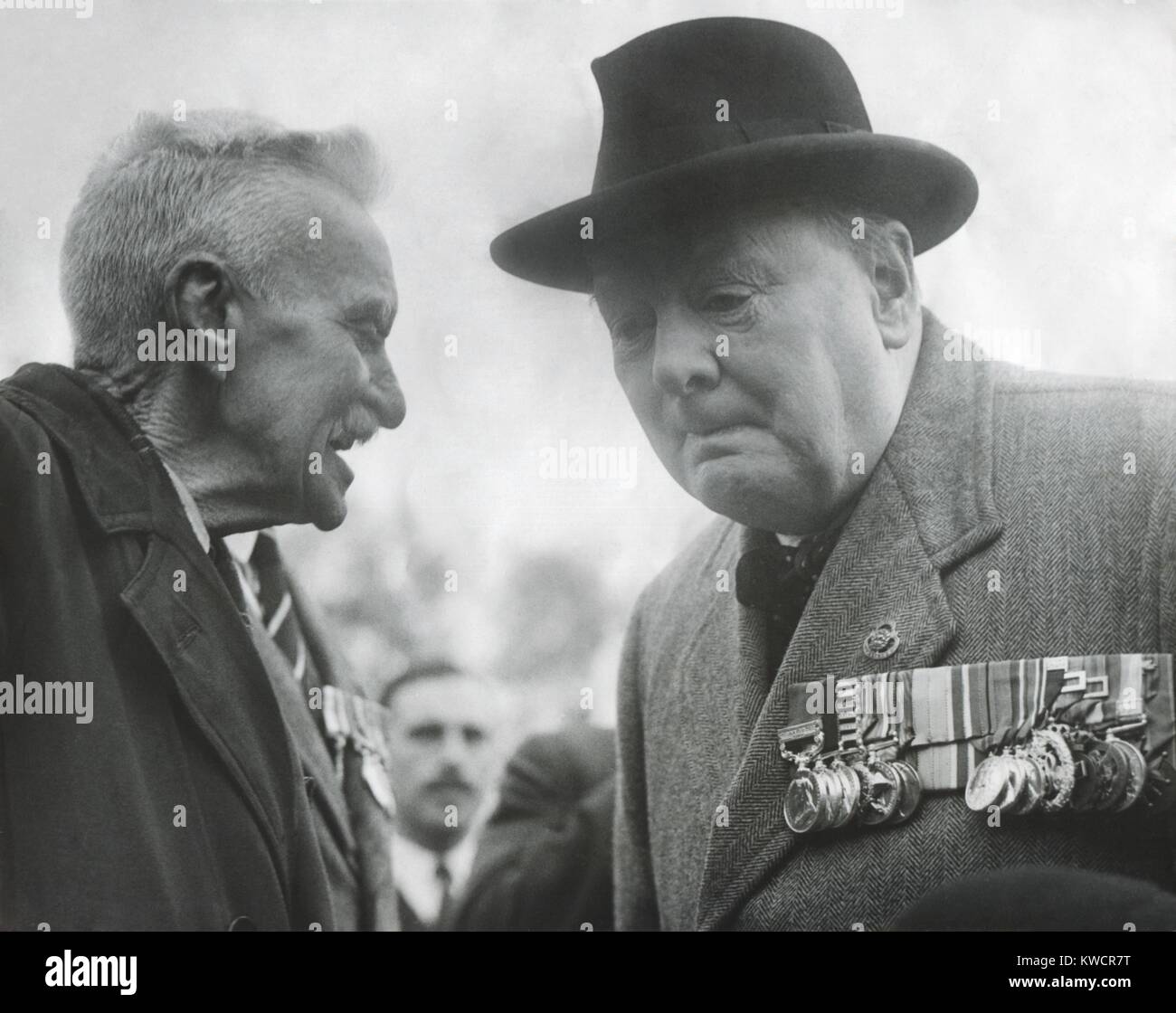 Winston Churchill, wearing his military medals, listening to an elderly man. Ca. 1945 - (BSLOC 2014 17 46) Stock Photo