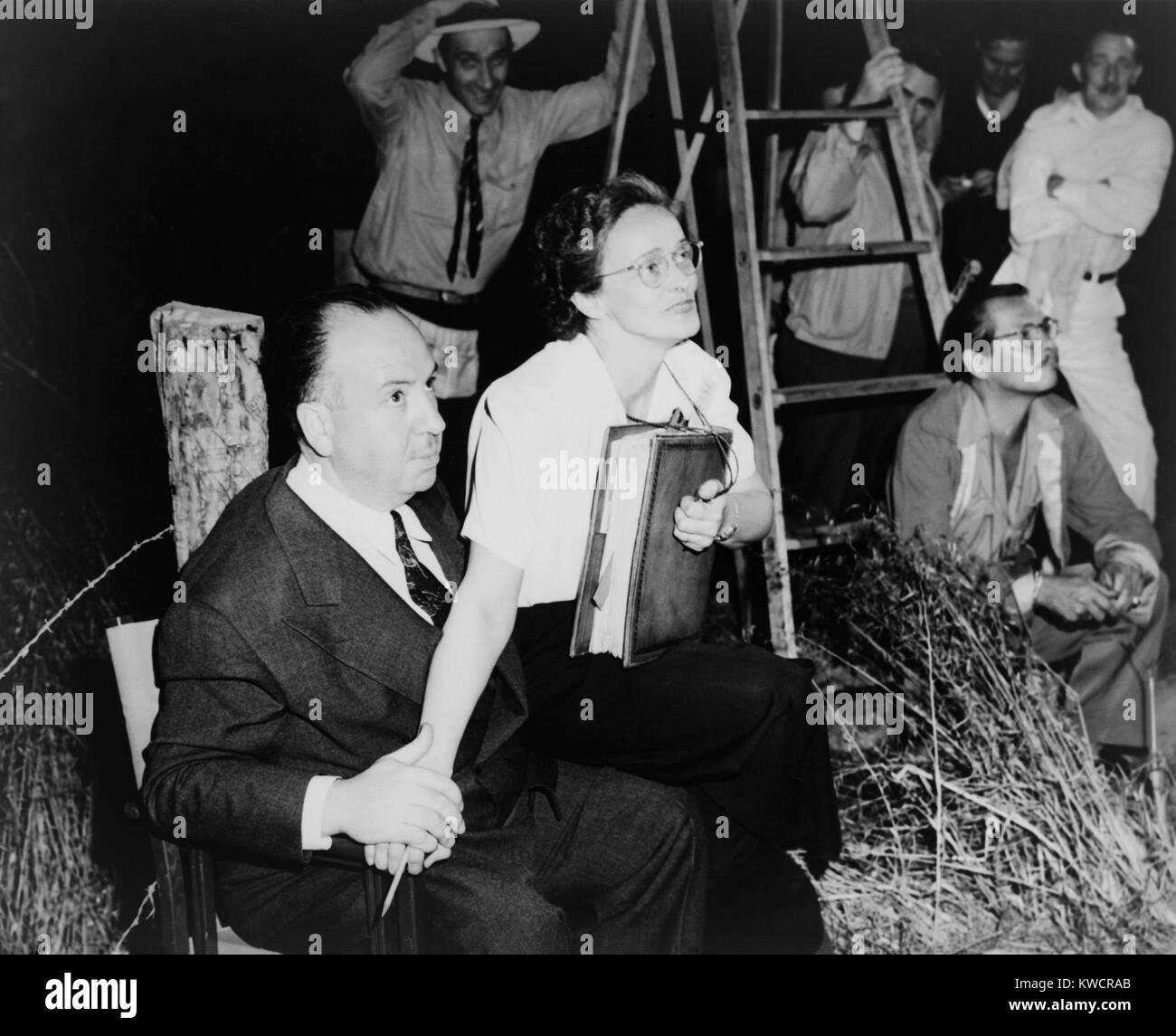 Alfred Hitchcock, seated with Adele Cannon on set of 'Spellbound'. Cinematographer George Barnes is in the background. 1946. - (BSLOC_2014_17_80) Stock Photo