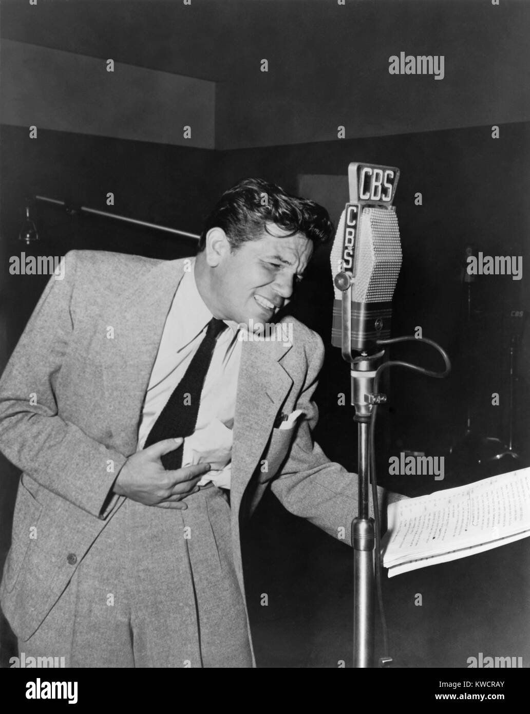 John Garfield, at CBS radio microphone, performing in the suspense play, 'Death Sentence'. 1949. It was aired on the long running series, SUSPENSE. - (BSLOC 2014 17 86) Stock Photo