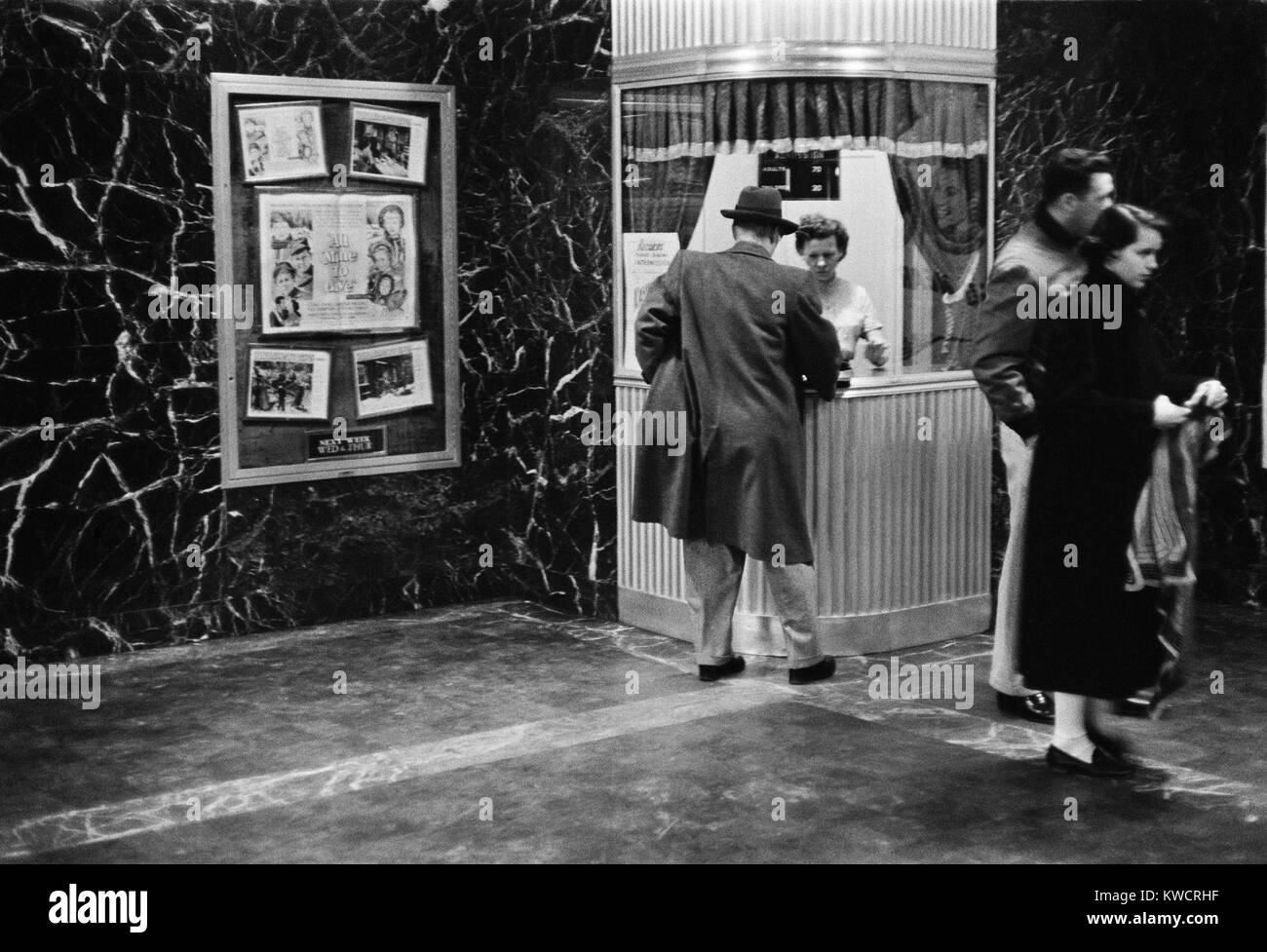 Man purchasing a movie ticket for the film. The coming attraction is the film, ALL MINE TO GIVE. Feb. 9, 1958. - (BSLOC_2015_1_162) Stock Photo