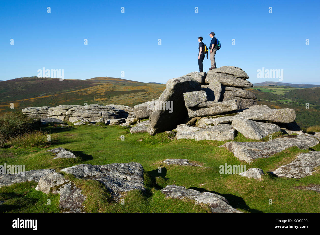 DARTMOOR NATIONAL PARK, DEVON, ENGLAND: Combestone Tor with hikers Stock Photo