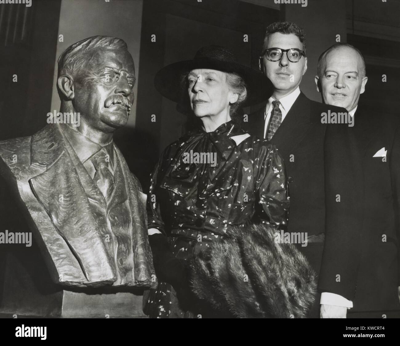 Remembrance as Theodore Roosevelt's bust is unveiled. Alice Roosevelt Longworth, Oscar Straus of the Theodore Roosevelt Association, and Harold Stassen, with the sculpture by Georg John Lober. In was installed in the Hall of Fame for Great Americans in the Gould Library at New York University. 1954. - (BSLOC 2015 1 54) Stock Photo