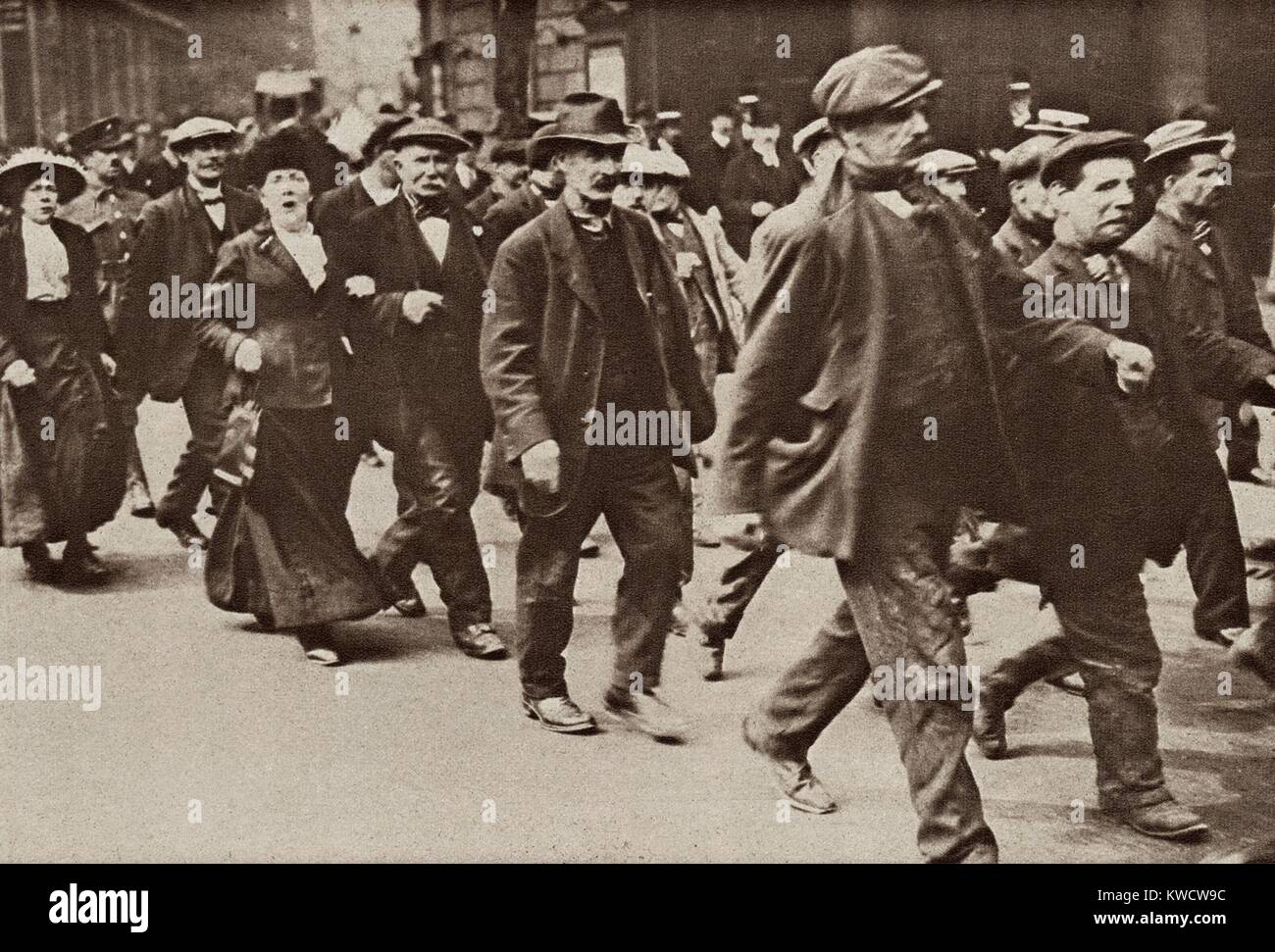 World War 1. Accompanied by their wives, middle aged men march to the central depot to be recruited into the British Army. In 1915, Britain still had an all volunteer army but lowered its standards to include these older men. (BSLOC 2013 1 3) Stock Photo