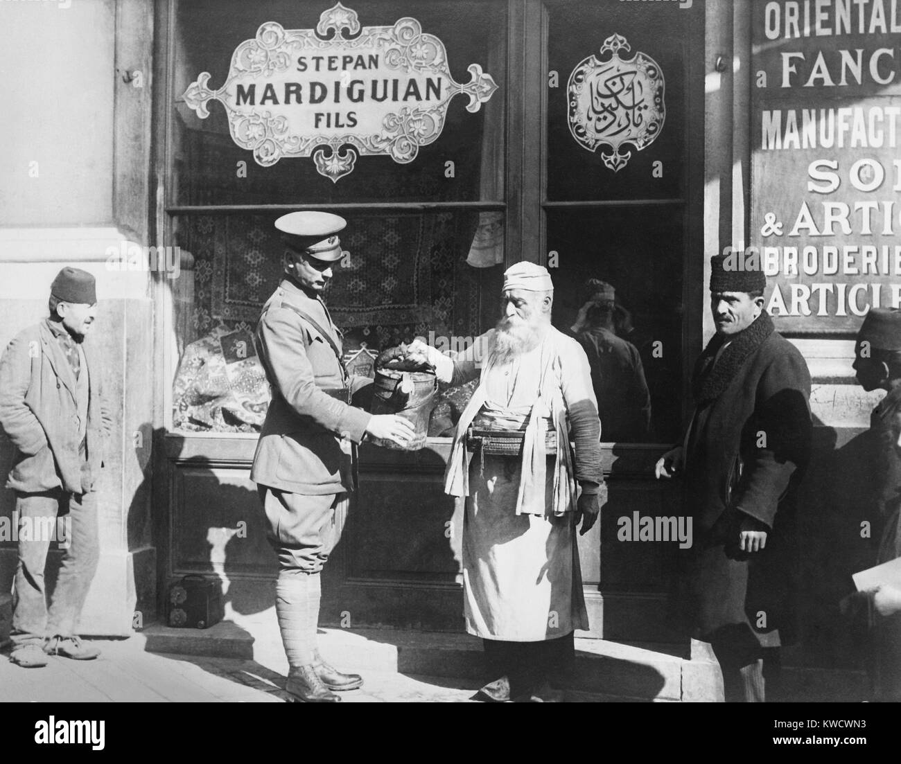 American solider of the Allied post-WW1 occupation forces in Istanbul in 1920. He is buying drinking water at 5 cents a glass from a street vendor to avoid typhoid and other diseases (BSLOC 2017 1 174) Stock Photo