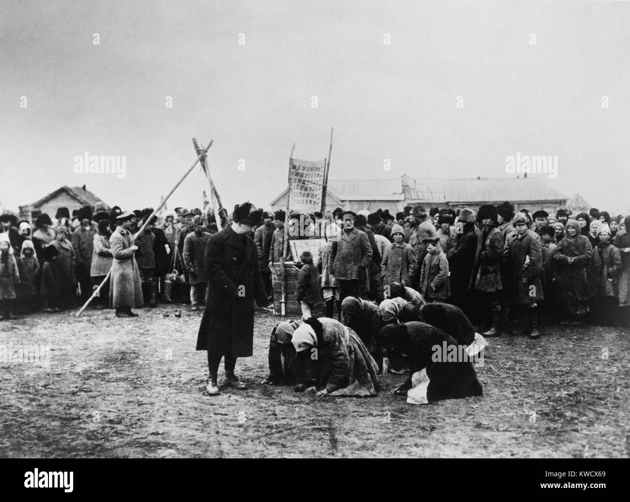 American Relief Administration distributing food in the Volga District, 1921. Russian women abjectly kneel nearby (BSLOC 2017 2 26) Stock Photo