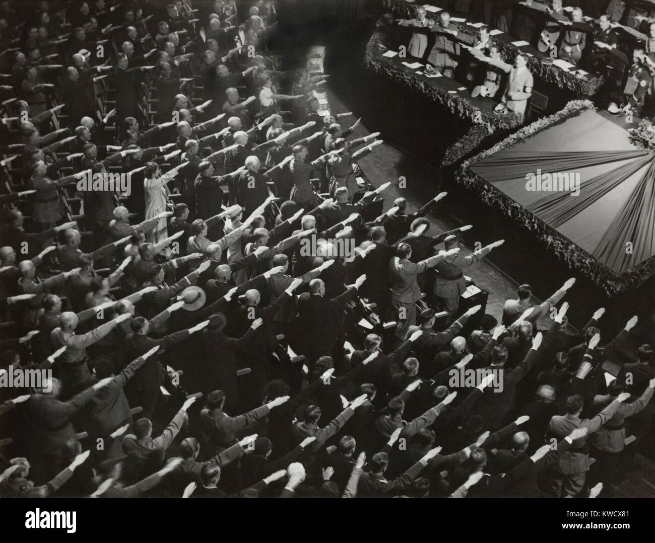 Attendees give Hitler the Nazi salute during the nation anthem, Oct. 9, 1935. They were meeting at the Kroll Opera in Berlin, to organize the Winter Relief festive to help finance charitable work (BSLOC 2017 2 69) Stock Photo