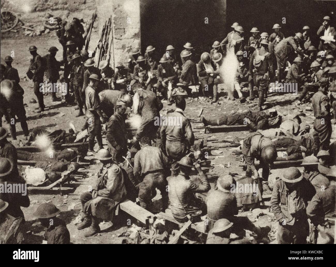 World War 1: American Red Cross First-Aid station in French town on the Western Front. Badly wounded soldiers have just been brought in from the battlefield on stretchers, while others, slightly wounded, wait their turn. In the summer of 1918 U. S. armies suffered casualties on the large scale associated with the battles of the Great War. (BSLOC 2013 1 191) Stock Photo