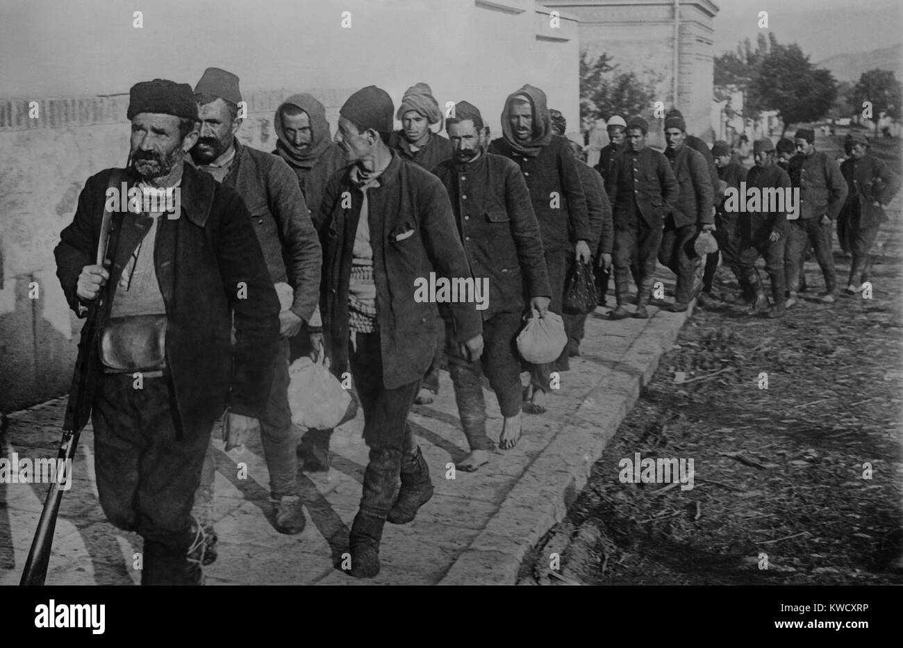 Turkish prisoners, led by an armed guard, enter Vrania, Serbia. During the First Balkan War, 1912-1913, Bulgaria, Serbia, Greece and Montenegro, united in the Balkan League, to push the weakened Ottoman Empire from Southeast Europe (BSLOC 2017 1 131) Stock Photo
