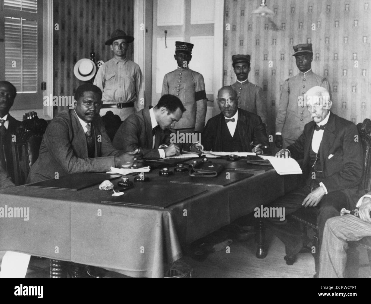 President Philippe Sudre Dartiguenave, seated, 2nd from left, with cabinet ministers, Nov. 1915. In the left background, stands his bodyguard, US Marine Sergeant H.E. Miller. Dartiguenave was from Haitis mulatto elite, and not supported by the nations poor black majority (BSLOC 2017 2 77) Stock Photo