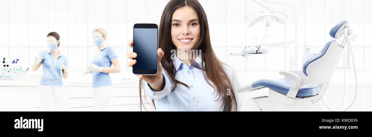 Dental Care Smiling Woman Showing Smart Phone On Dentist Clinic