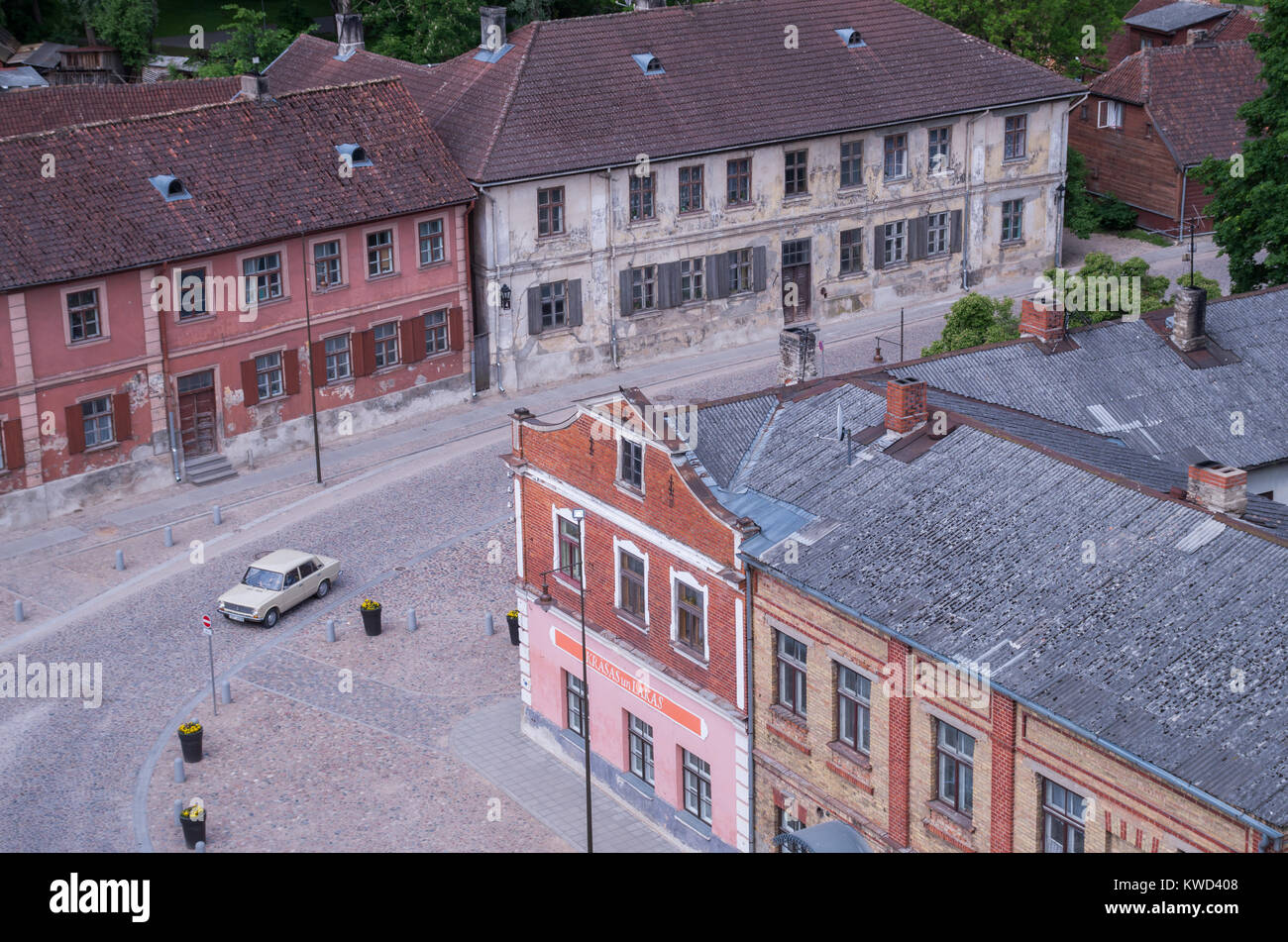 A view of old buildings in historical centre of Kuldiga a known latvian tourism attraction. As seen from local church tower with an old soviet ca. Stock Photo