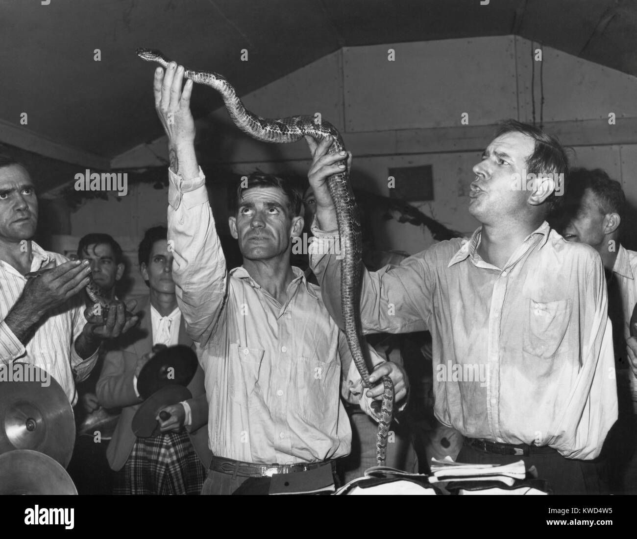 Men Handling serpents at the Pentecostal Church of God. Snake handling was a test of the worshipper's faith, introduced to Appalachia in the early 20th century by George Went Hensley. Lejunior, Harlan County, Kentucky. Sept. 15, 1946. Photo by Russell Lee. (BSLOC 2014 13 185) Stock Photo