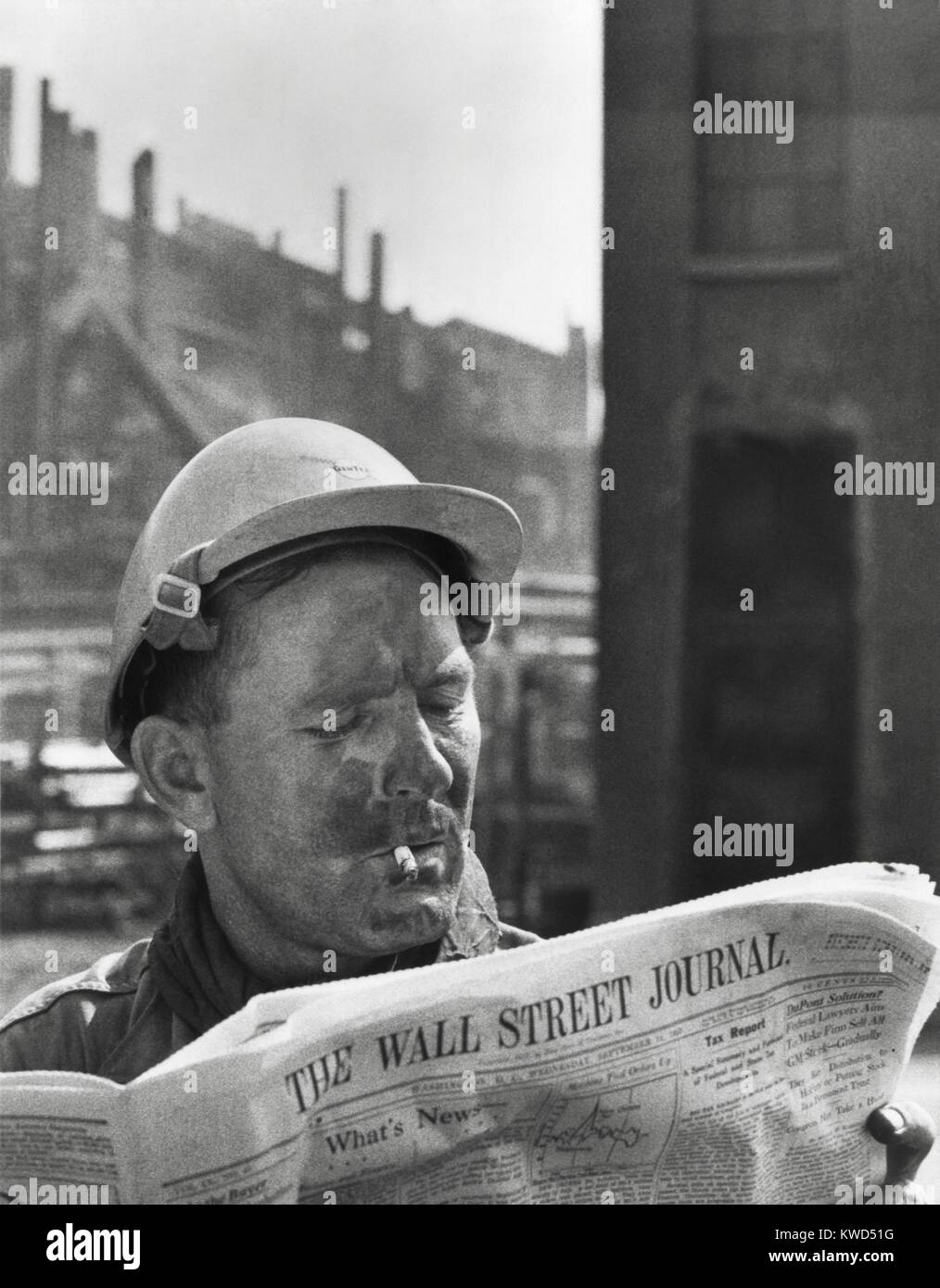 An electrician reads 'The Wall Street Journal' to check his stock market investments. Employed by Monsanto, he invests in the company through the corporation's 'Stock Purchase Plan' for its workers. Ca. 1958. (BSLOC 2014 13 231) Stock Photo