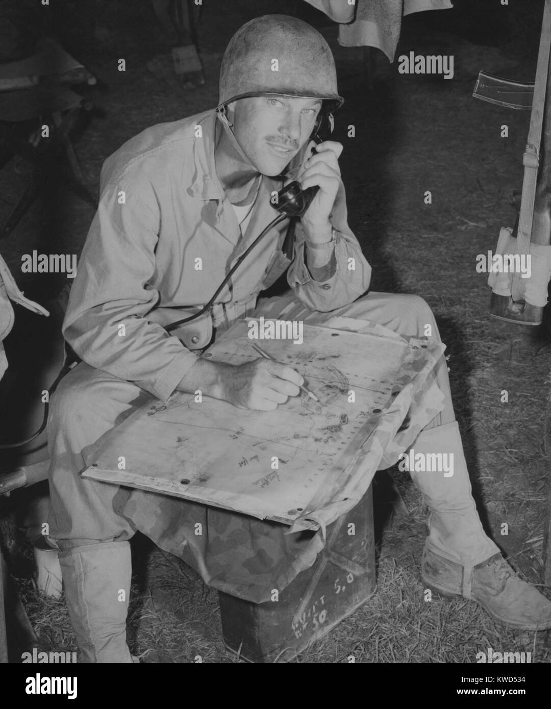 Lt. Col. Raymond Murray taking a message over field phone and plotting positions on a map, August 23, 1950. With his unit, he participated in the battles of the Naktong River perimeter, Wolmi-Inchon, Seoul, and Wonsan; and in the Marine advance north toward the Yalu River. Korean War, 1950-53. (BSLOC 2014 11 17) Stock Photo