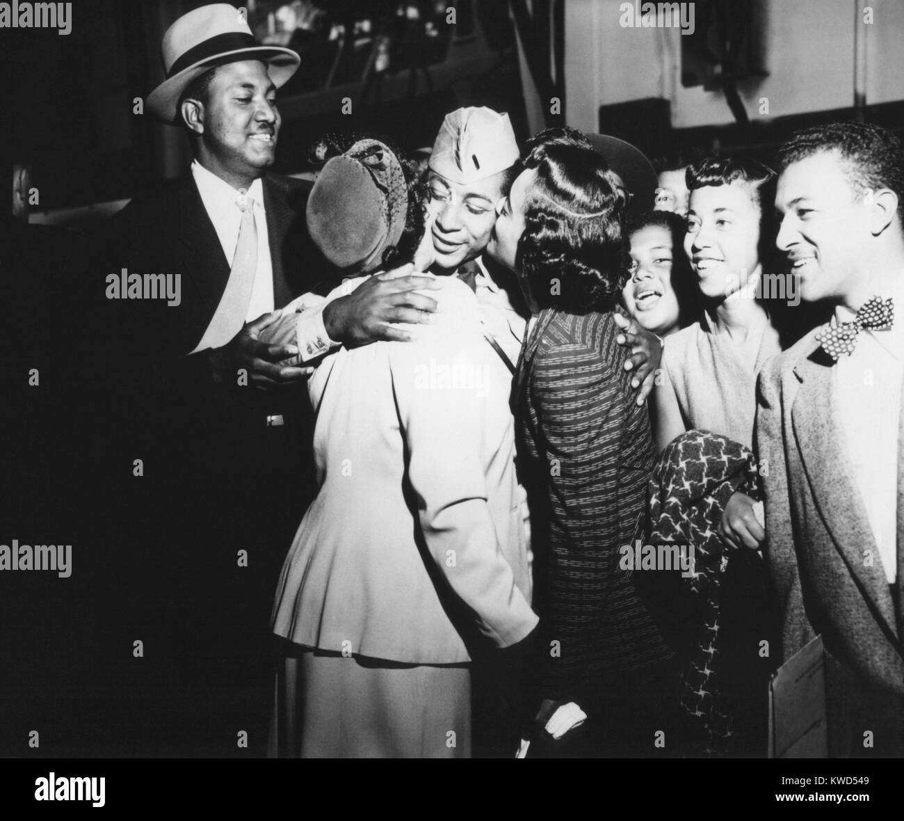 Army First Lt. Alvin Anderson embracing his mother and sister as his family looks on. He spent 33 months as a POW during the Korean War. Sept. 14, 1953. Fort Mason, California. Korean War, 1950-53. (BSLOC 2014 11 181) Stock Photo