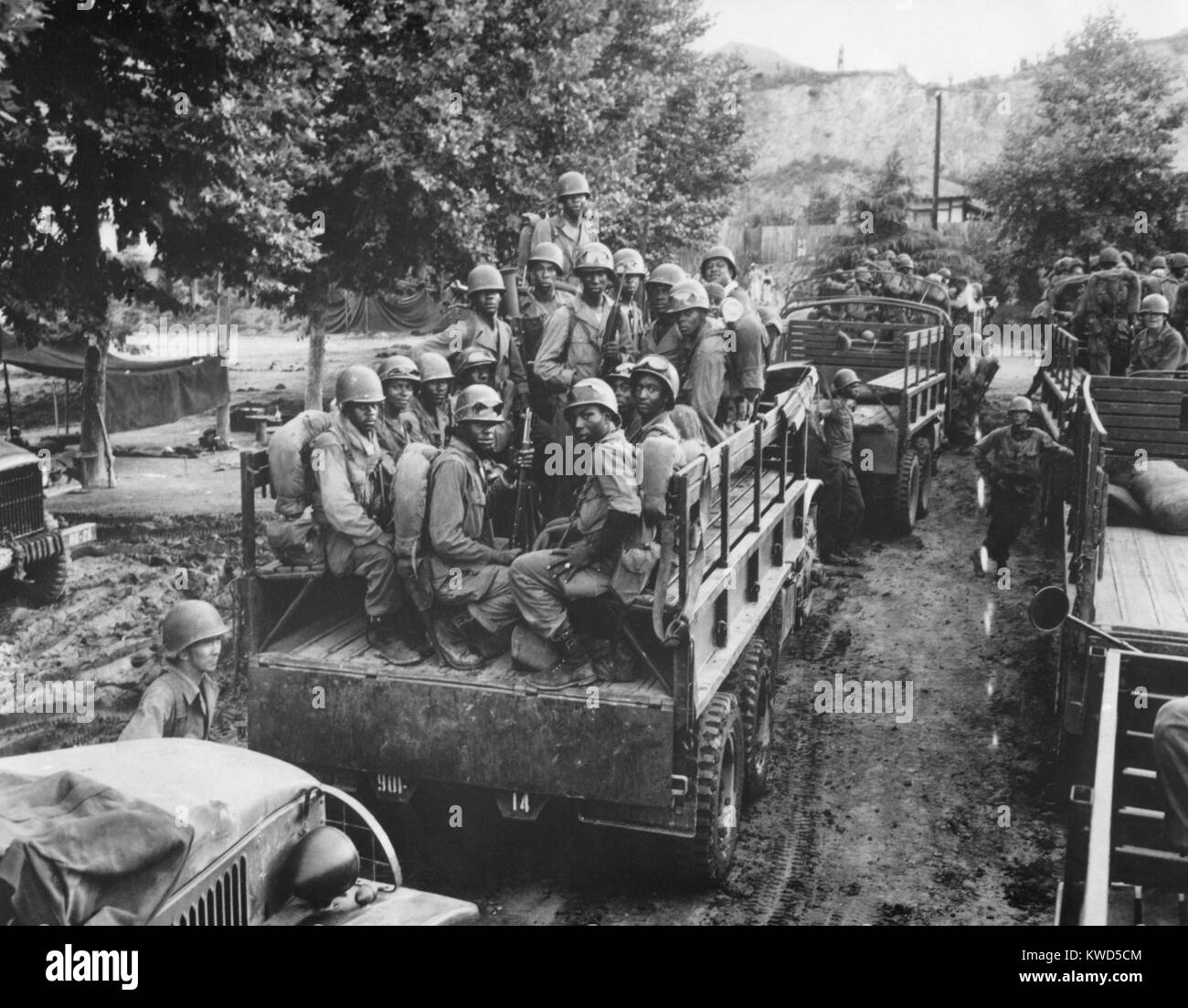 U.S. Soldiers move up to the firing line in Korea on July 18, 1950. Troops on occupation duty in Japan were the first fight the North Korean invaders. African Americans in the near truck are with the now integrated 24th Infantry Regiment. Korean War, 1950-53. (BSLOC 2014 11 8) Stock Photo
