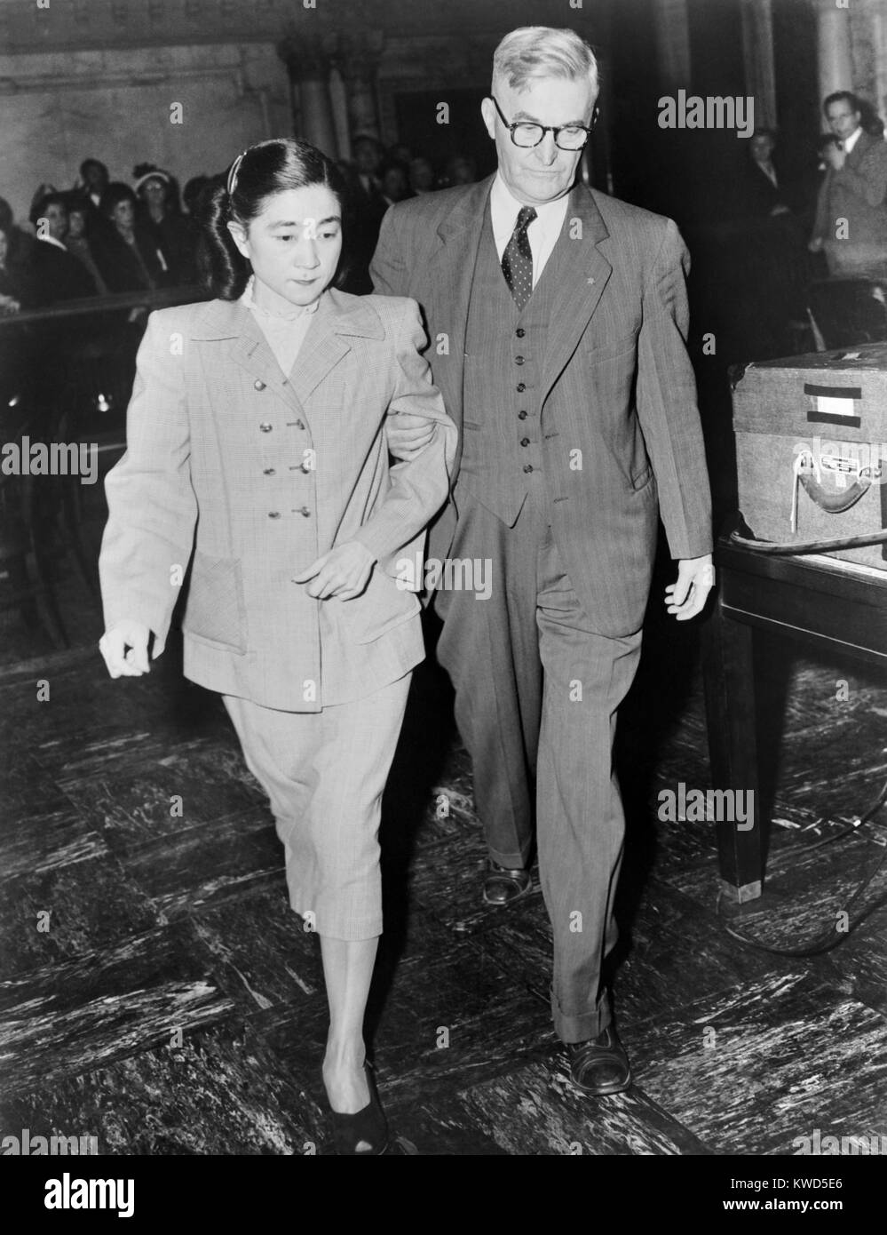 Iva Toguri D'Aquino led from Federal Court in San Francisco by a U.S. Marshall. Based on perjured testimony, the former 'Tokyo Rose' was sentenced to ten years in prison and fined $10,000 in 1949. She served six years in prison, but was later pardoned by President Gerald Ford. (BSLOC 2014 13 11) Stock Photo