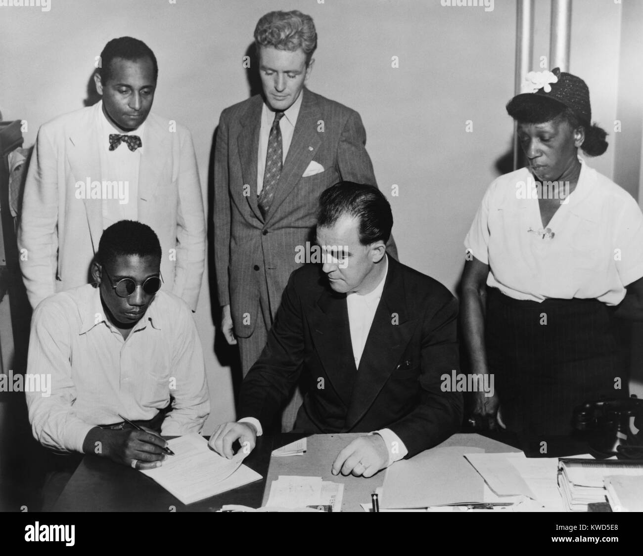 African American veteran Isaac Woodard was blinded by Batesburg, South Carolina police. Feb. 12, 1946. He was arrested, and beaten in jail in apparent retaliation for arguing with a bus driver. He was still in his military uniform, hours after being honorably discharged from the United States Army. In photo, NAACP staff assist him in preparing his disability claim to the Veterans administration. (BSLOC 2014 13 111) Stock Photo