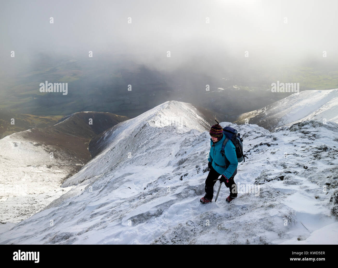 Walker Nearing the Top of Hall's Fell Ridge on Blencathra in Winter Conditions, Lake District, Cumbria, UK Stock Photo