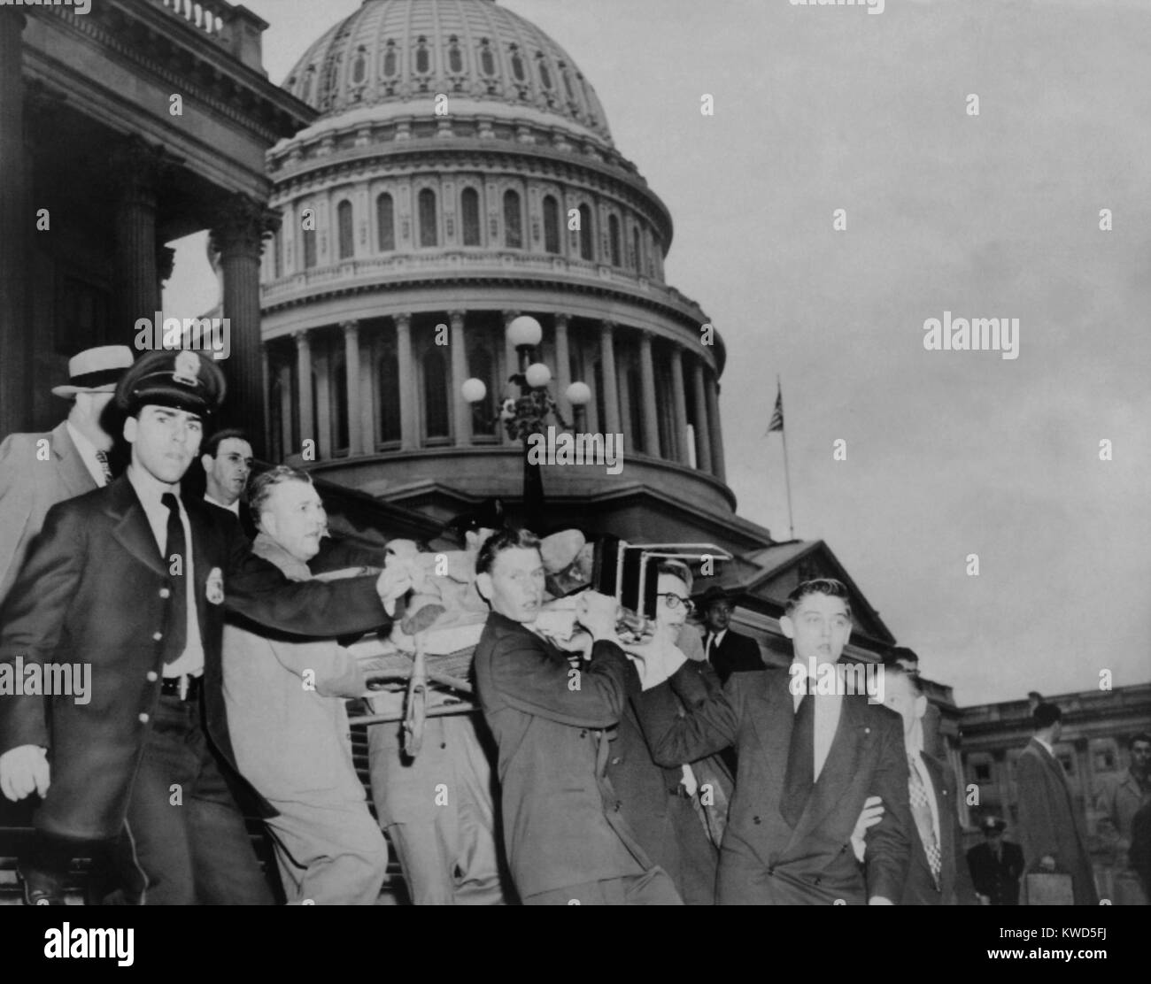 Aftermath of the Puerto Rican terrorist shooting in the U.S. House of Representatives. Police and aids carry Rep. Kenneth Roberts from the House where he suffered leg wound. March 1, 1954. (BSLOC 2014 13 137) Stock Photo