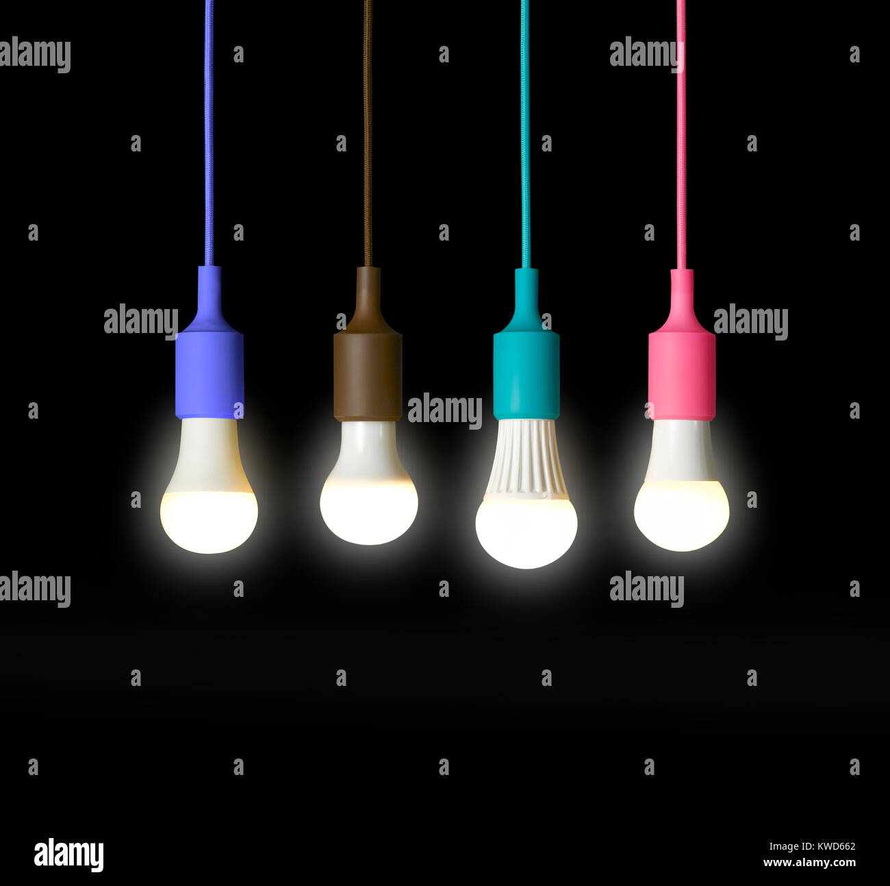 a shot of four light bulbs in four different coloured pendant holders against a black background Stock Photo