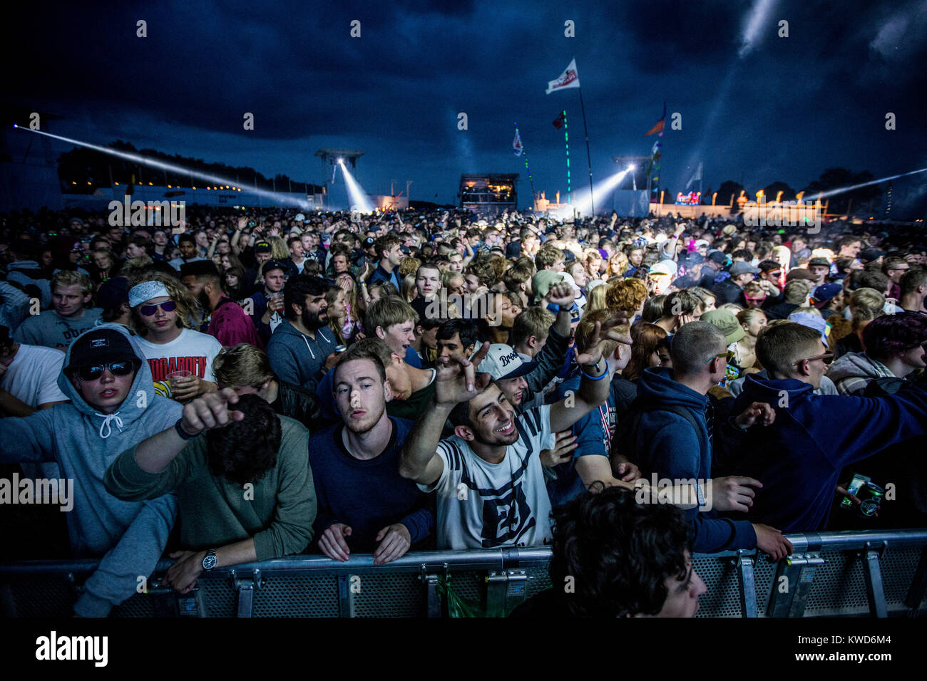 Energetic festival goers and music fans go crazy front row at a