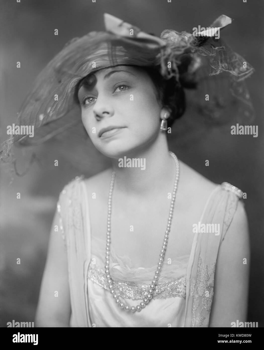 New York Socialite Miss Inez Thomas modeling a hat, long string of pearls, and evening gown. Ca. 1920. (BSLOC 2015 16 245) Stock Photo