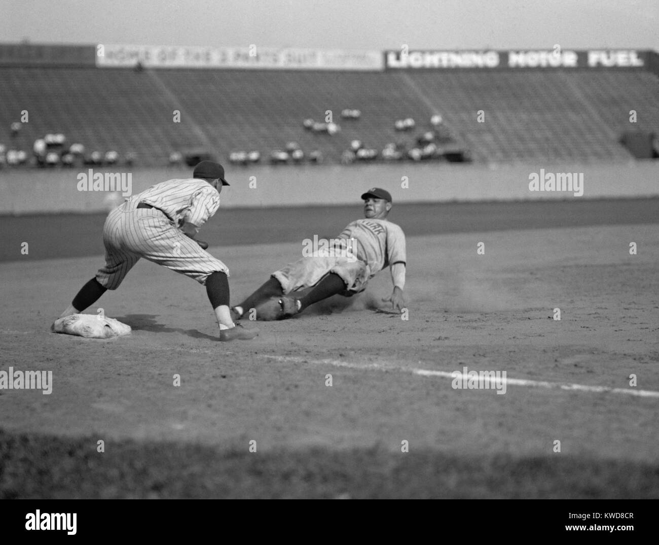 Babe Ruth slides in safe at third base on Bob Meusel's fly out. Senators third baseman is Ossie Bluege. 1925. (BSLOC 2015 17 29) Stock Photo