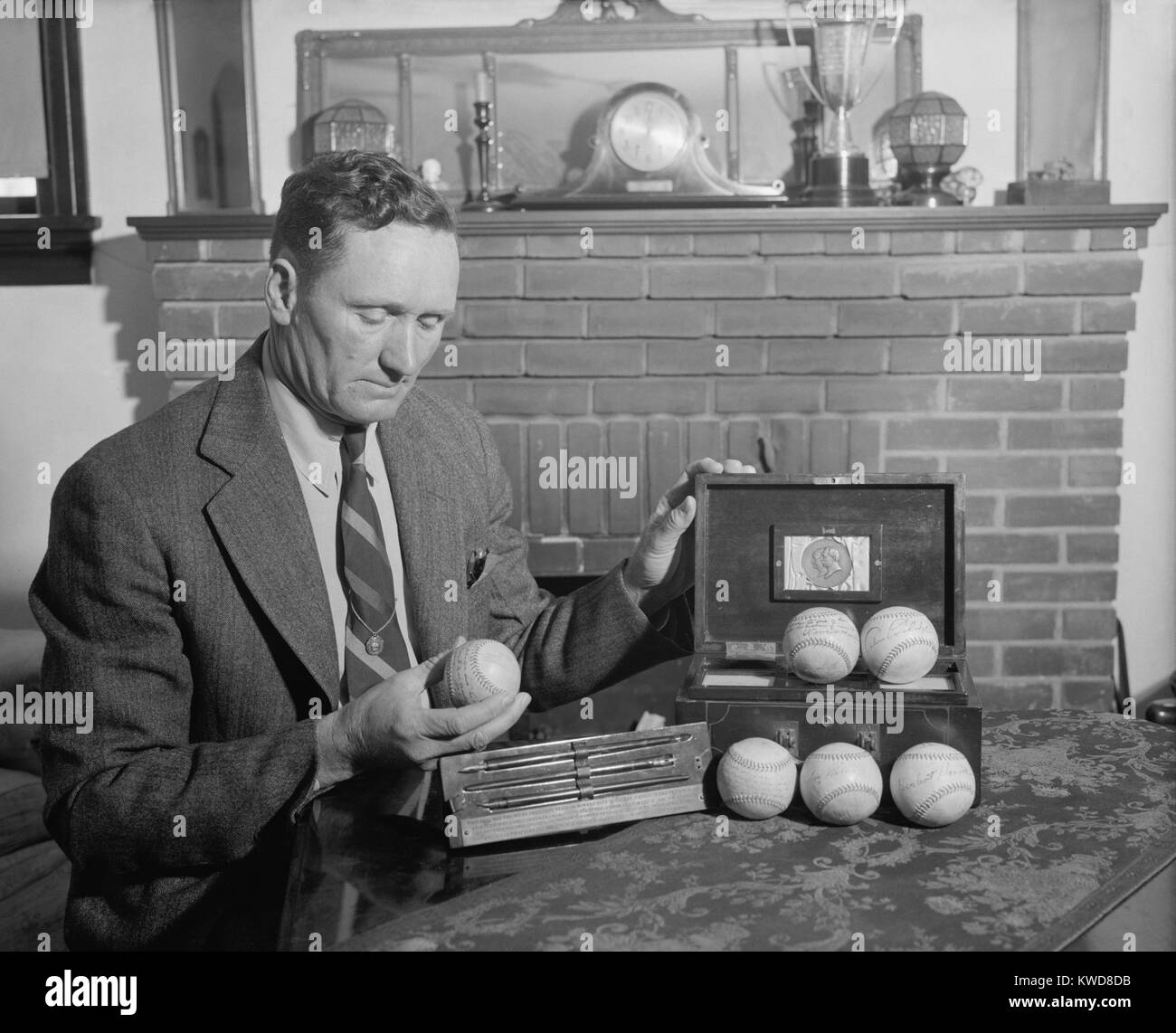 Retired baseball legend Walter Johnson with souvenir balls signed by six presidents: Theodore Roosevelt, William Taft, Woodrow Wilson, Warren Harding, Calvin Coolidge, and Herbert Hoover. Four of the balls were thrown out a season openers. April 1939. (BSLOC 2015 17 40) Stock Photo