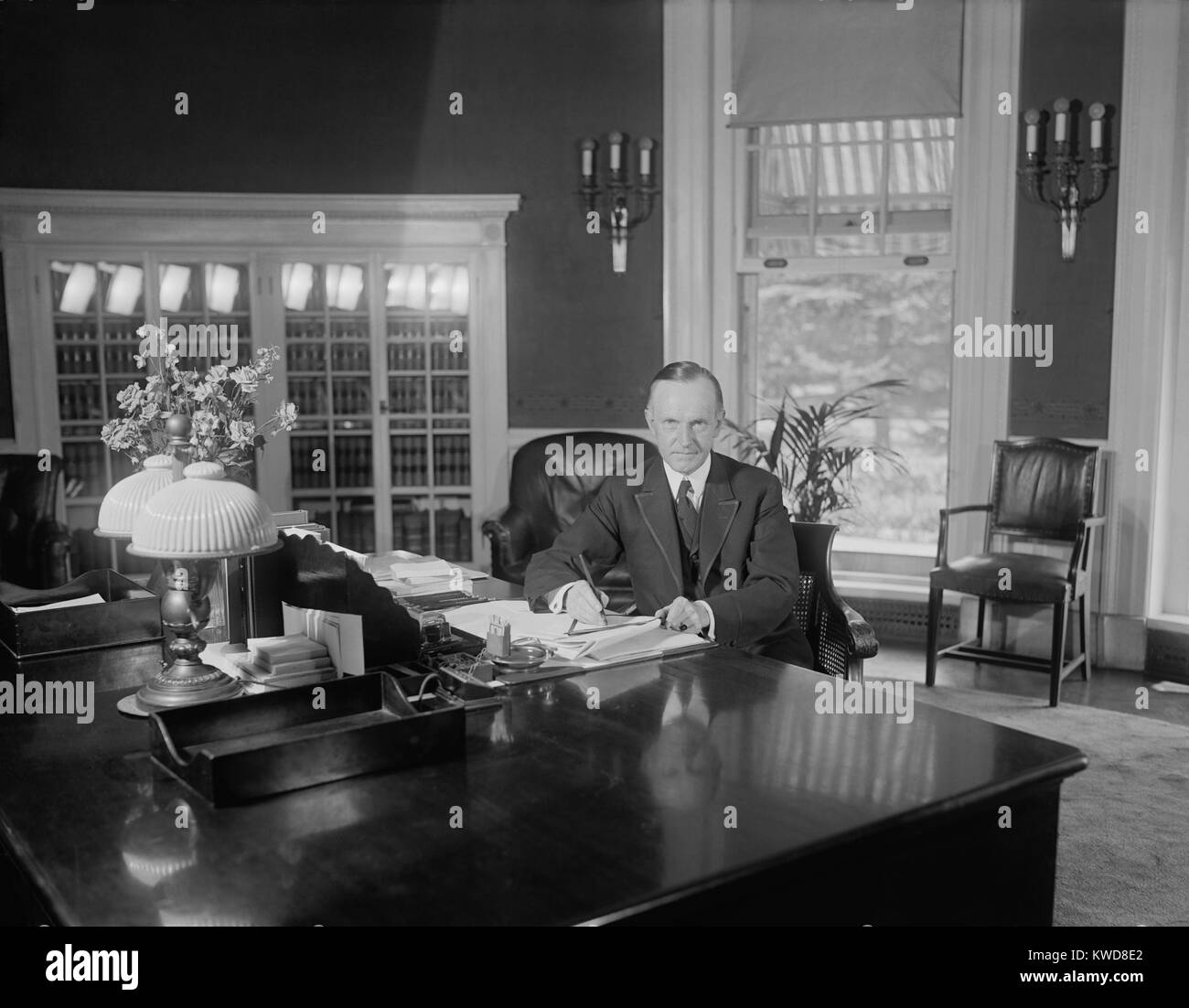 President Calvin Coolidge at the same desk used by Harding in the Oval Office. Photo was published on Aug. 14, 1923, less than two weeks after the death of Warren Harding. Florence Harding was upset that Coolidge sat at this desk for photographers before Warren Harding's body returned to the White House. (BSLOC 2015 15 97) Stock Photo