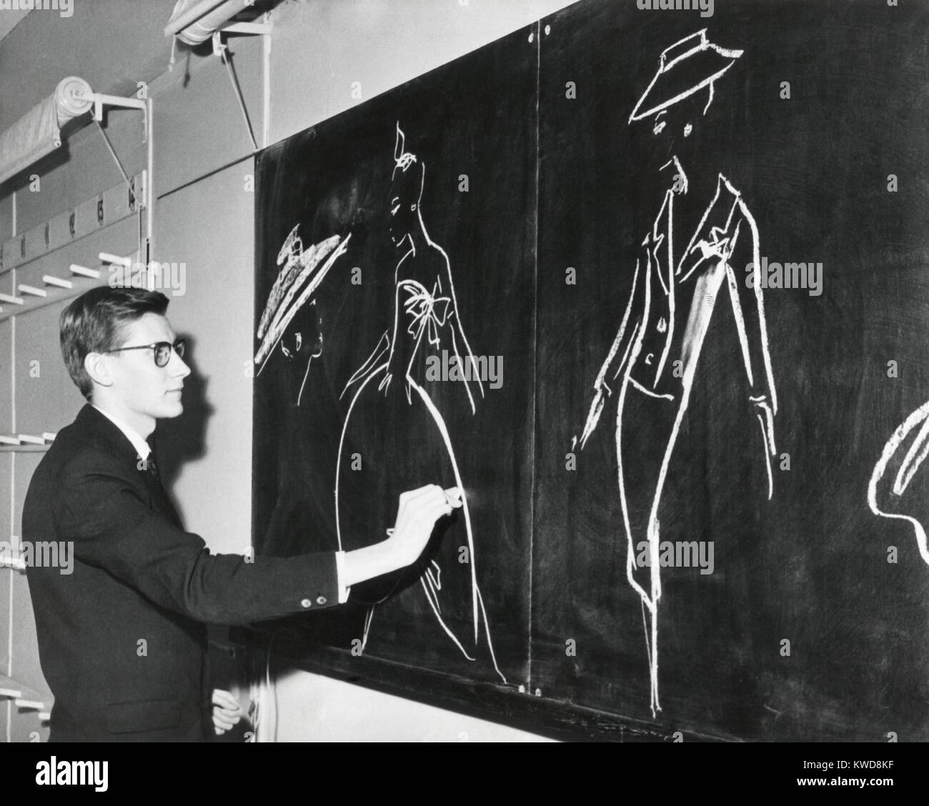 Yves Saint Laurent sketching designs for Christian Dior 1958 fashion line in Paris. At the age of 21 , he became the head designer of the House of Dior, after Dior's death in 1957 (BSLOC 2016 7 10) Stock Photo
