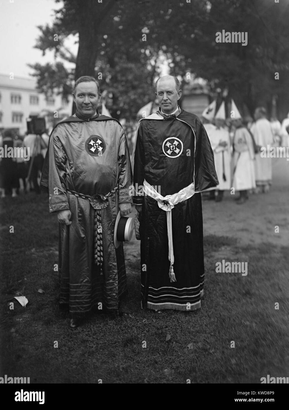 Hiram W. Evans, Grand Wizard of the Ku Klux Klan, with Kansas Grand Dragon Charles H. McBrayer. August 8, 1925. They lead a march along Pennsylvania Avenue and the National Mall in which an estimated 25,000 to 35,000 Klansmen participated. Their robes bear the 'MIOAK', an acronym for 'Mystic Insignia of a Klansman.' It is commonly called 'the Blood Drop Cross'. (BSLOC 2015 16 170) Stock Photo