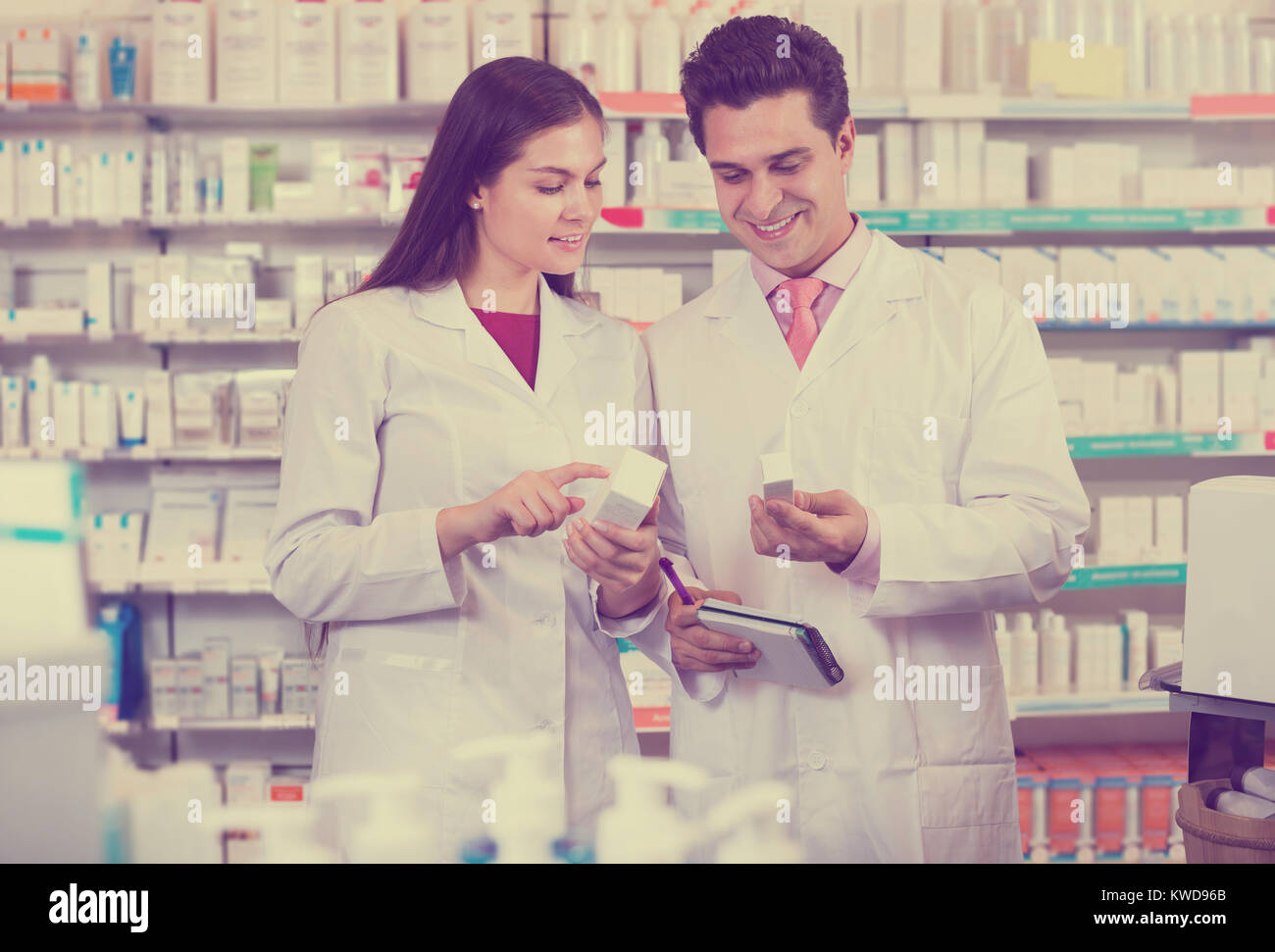 Young happy team of pharmaceutist and technician working at chemist shop Stock Photo
