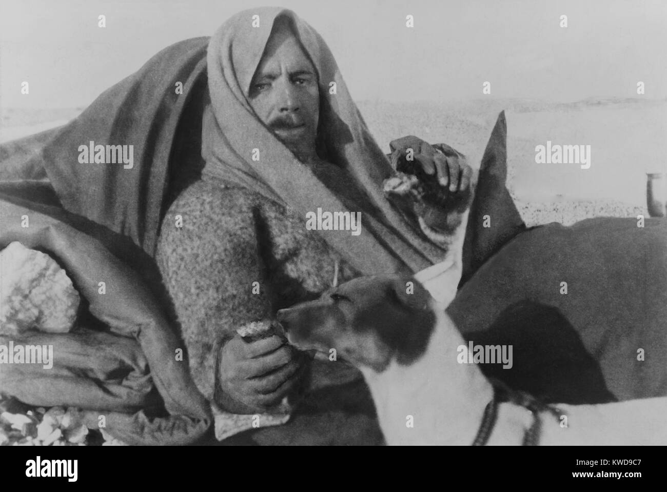 Arctic explorer Umberto Nobile after the crash of the dirigible ITALIA on May 25, 1928. Nobile and five survivors were stranded on drifting pack ice for seven weeks after the May 25, 1928 crash. He is feeding the expedition mascot, dog Titina. Seven crewmen were lost in the initial accident (BSLOC 2016 10 135) Stock Photo