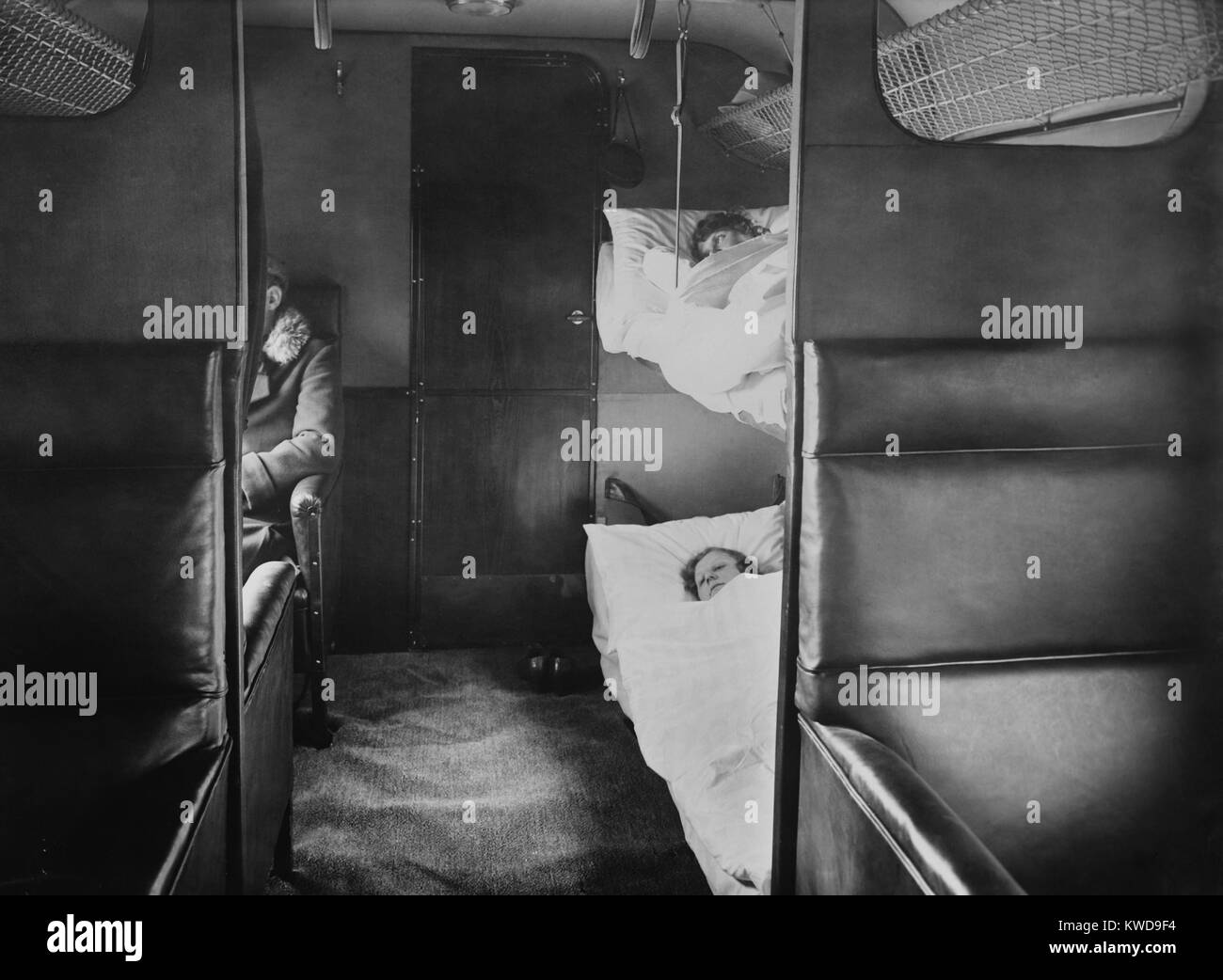Interior of Junkers' plane with passenger sitting in leather armchair seats. In the foreground are sleeping bunks (BSLOC 2016 10 166) Stock Photo