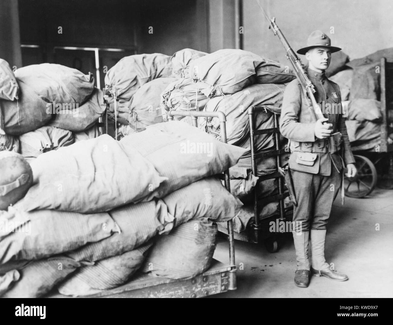U.S. Marine standing guard over sacks of mail, Washington, D.C. From 1919 to 1921, about $6 million was lost to mail robbers, who targeted Register Mail, which was used to send cash, jewelry, and negotiable securities (BSLOC 2016 10 91) Stock Photo