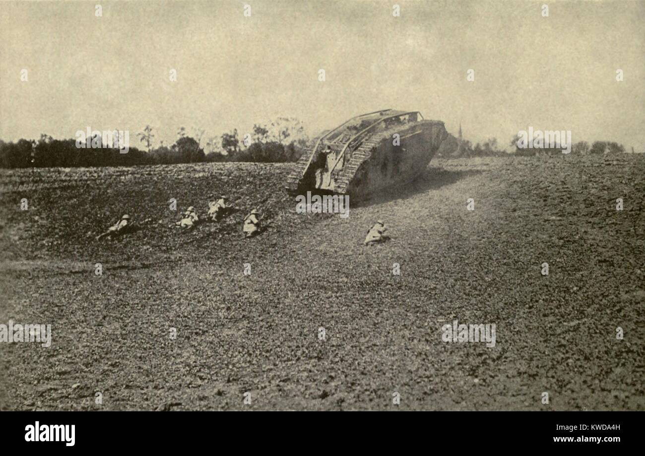 World War 1 Tanks. U.S. soldiers (107th Infantry, 27th Division) advancing toward the Hindenburg Line from behind the shelter of a British tank. 1918. (BSLOC 2013 1 155) Stock Photo