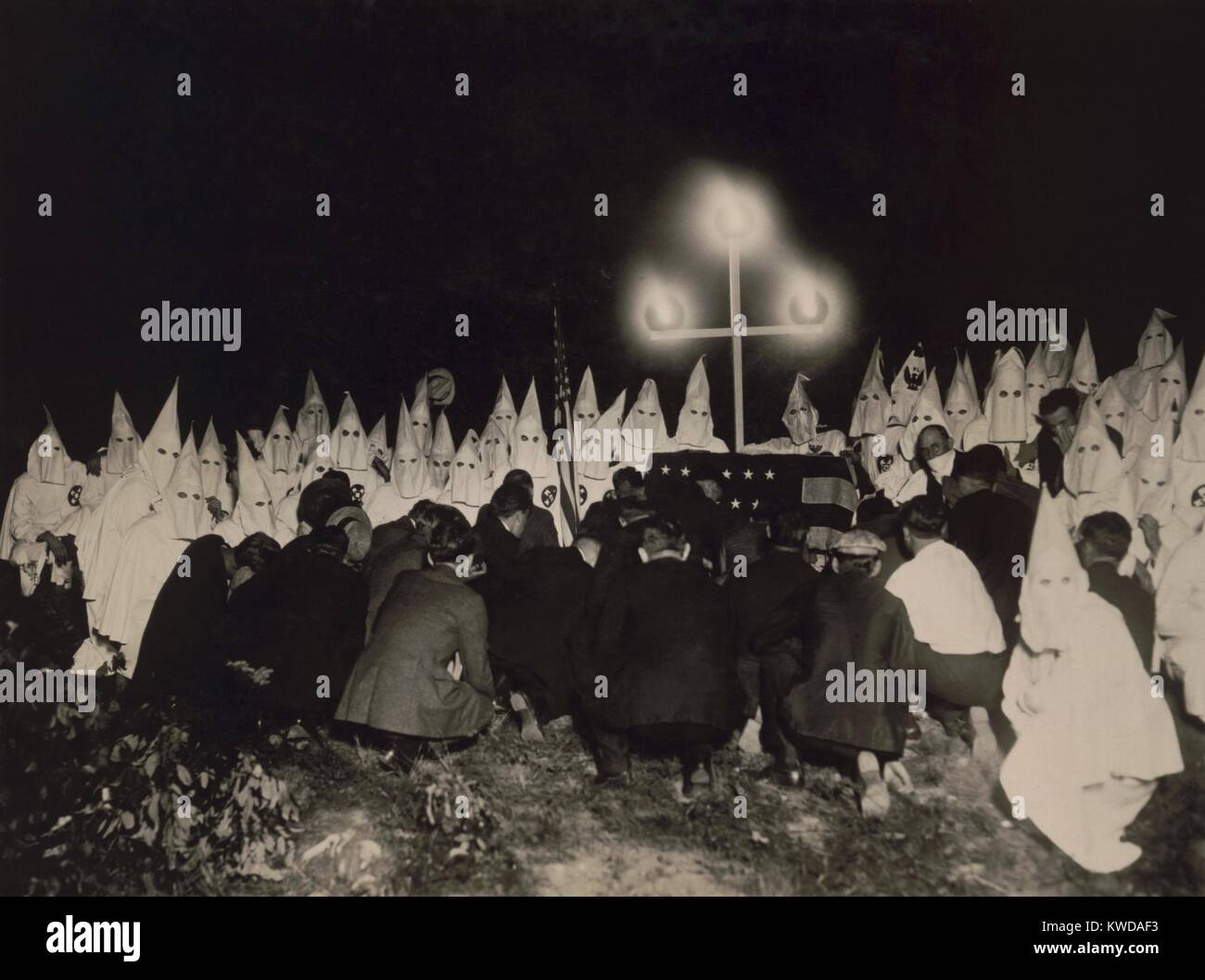 Ku Klux Klan gathered within two miles of the U.S. Capitol to receive new members, c. 1925-27. In the background are shrouded members, with the initiates kneeling in the foreground (BSLOC 2016 8 78) Stock Photo