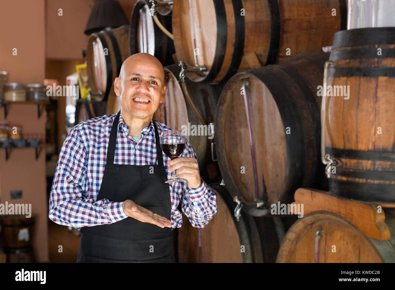 man wearing apron holding wine in wine house Stock Photo - Alamy