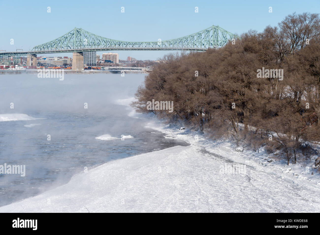 Montreal, CA - 1 January 2018: Jacques Cartier bridge and Parc Jean Drapeau as ice fog rises off the St. Lawrence River Stock Photo