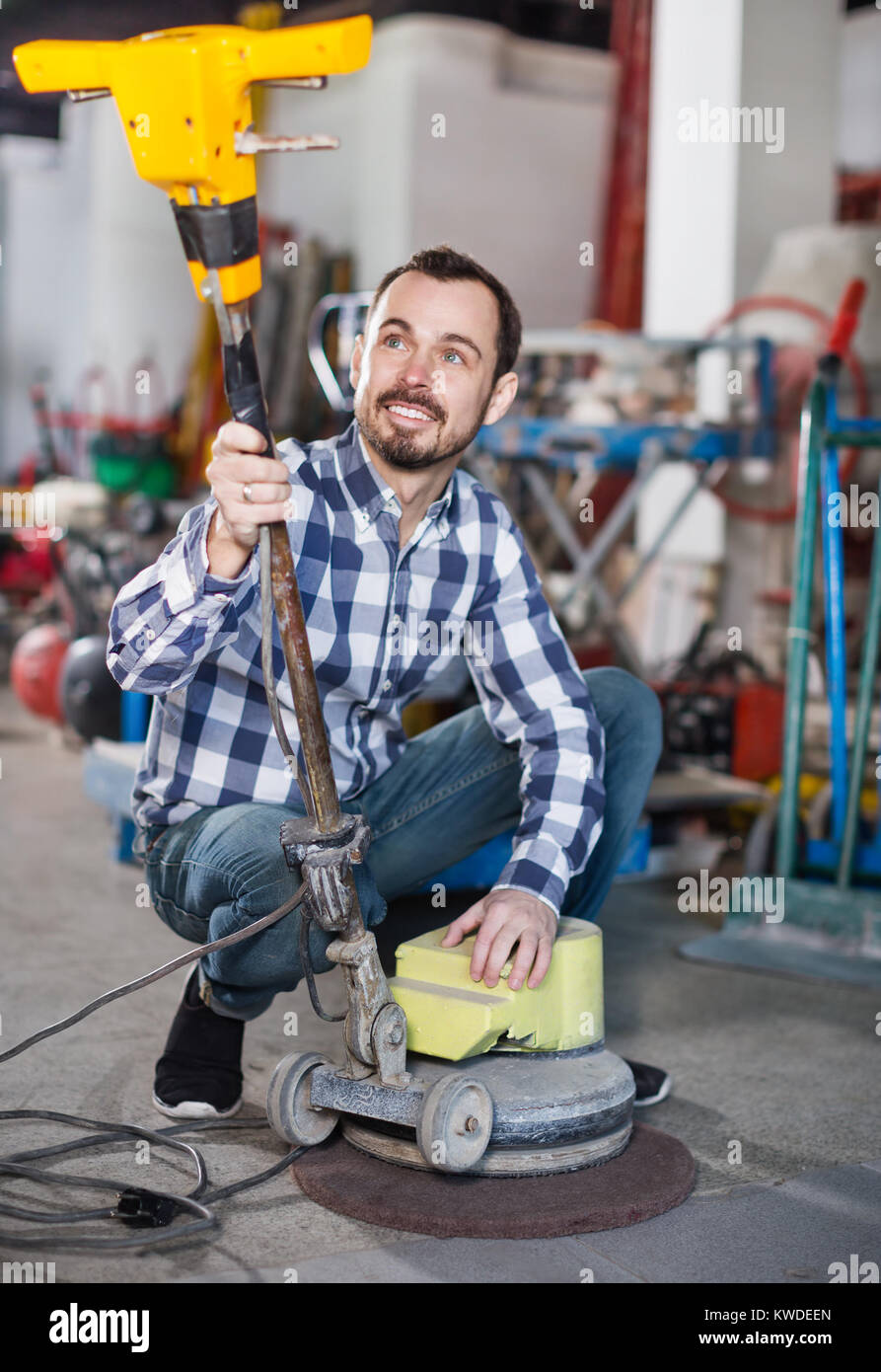 Smiling working man practicing his skills with a disk sander at ...
