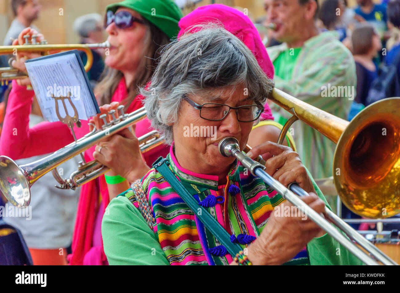 Female musician wearing glasses and playing a trombone in the Carnival